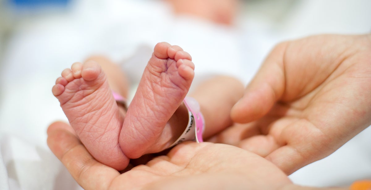 neonatal-nurse-holding-infant-feet