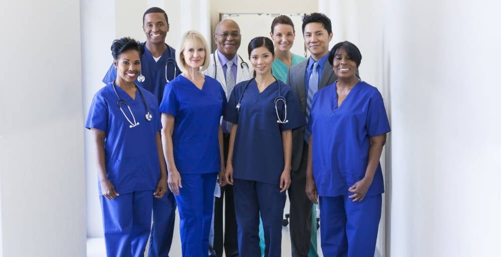 A group of nurses wearing blue scrubs