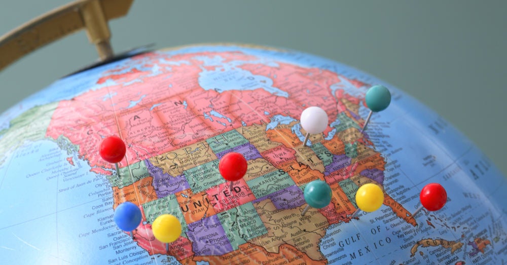 A globe focused on the United States with pins in major cities