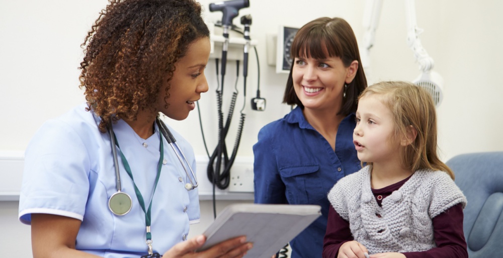 Nurse practitioner giving exam to child with her parent