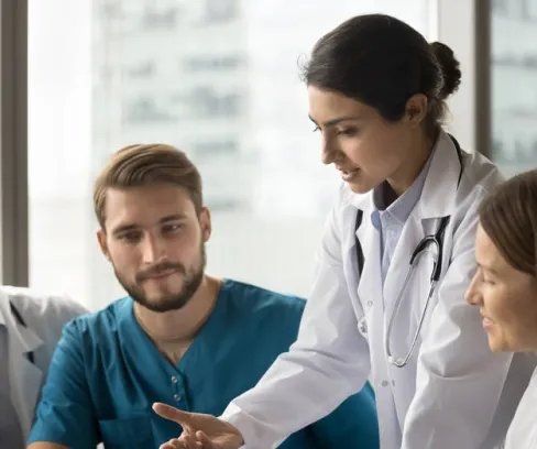 A nurse practitioner going over patient notes with nursing students doing their hospital clinical placement.